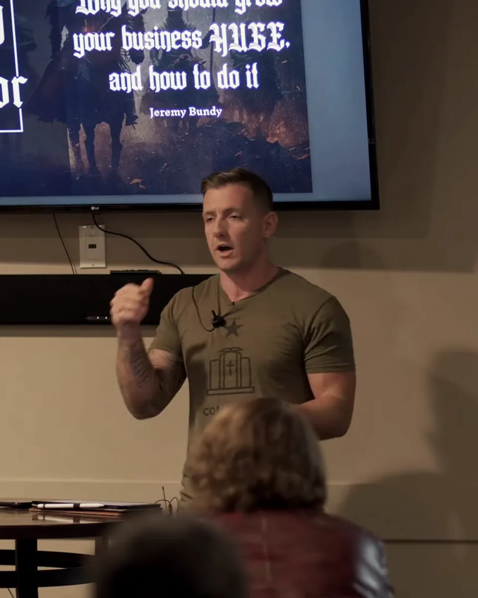 Jeremy Bundy explaining a point to a room, a presentation on the screen behind him.